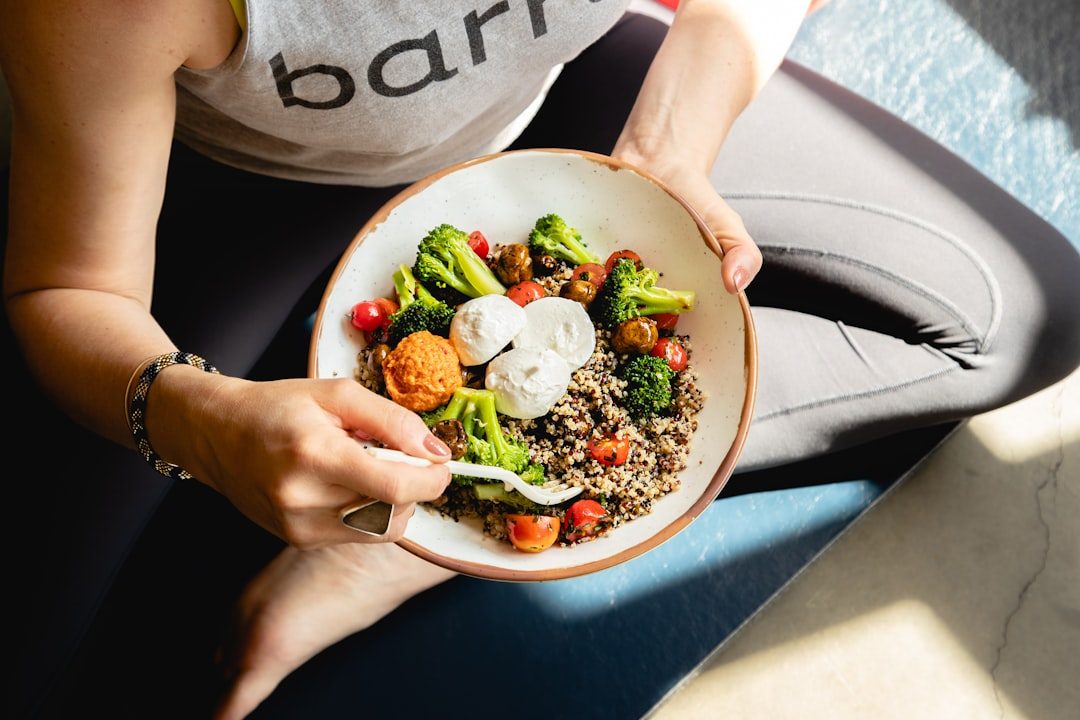 A woman holding a nourishing grain and vegetable bowl